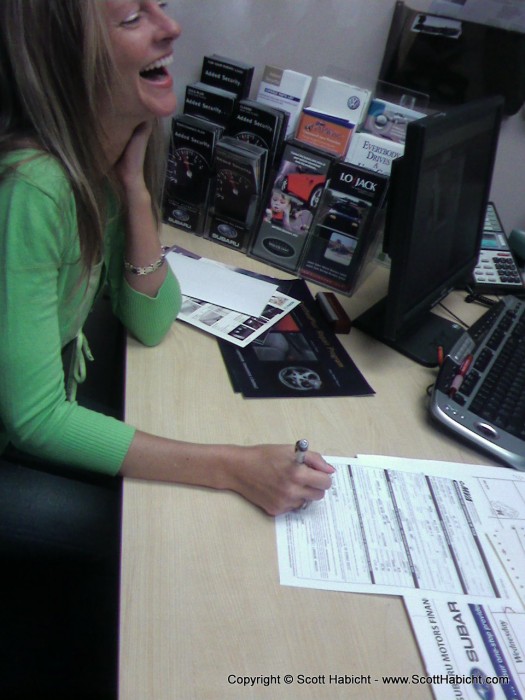 Kelli signs her name for her new car.