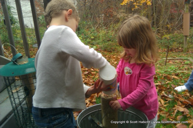 Taylor and Amber fill the bird feeders with food.