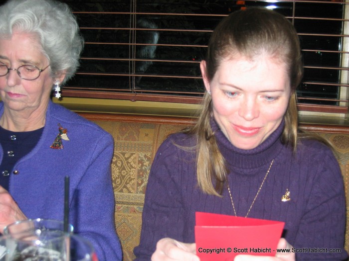 They exchange Christmas cards at the table.